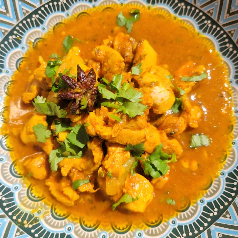 Cali Tarka's chicken curry with cilantro and star anise in a decorative bowl.